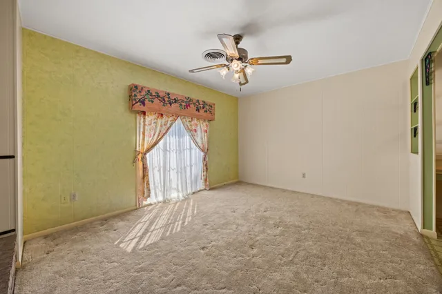 a view of a livingroom with a ceiling fan and window