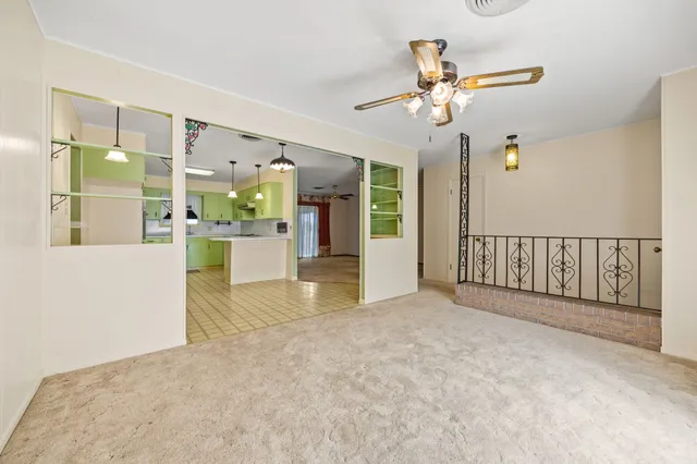 a view of a hallway with chandelier fan and windows