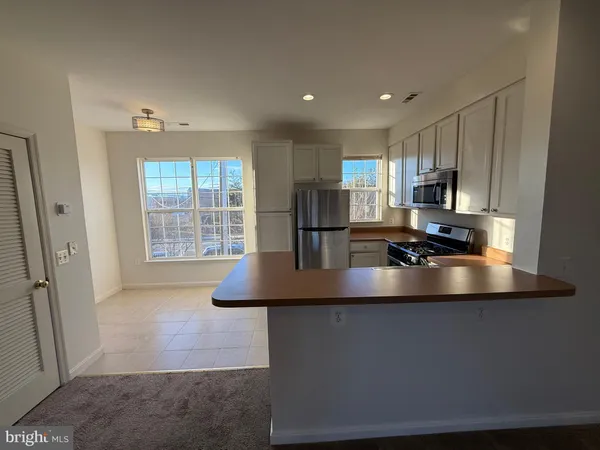 a kitchen with stainless steel appliances a refrigerator a stove a microwave and cabinets