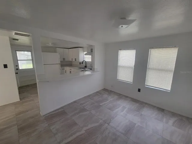 a kitchen with cabinets appliances a sink and a window