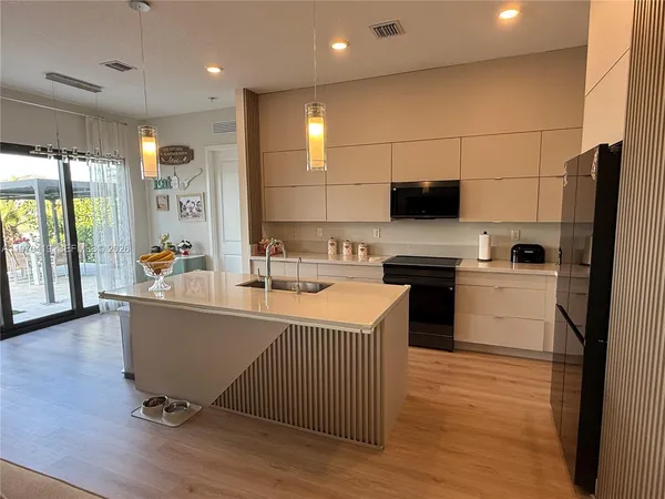 a kitchen with a sink appliances and cabinets