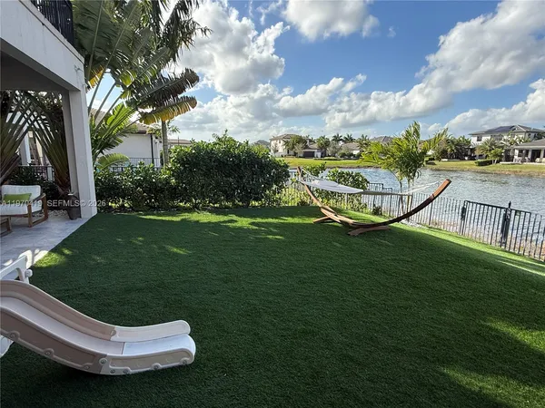 a view of a swimming pool with lawn chairs and a yard
