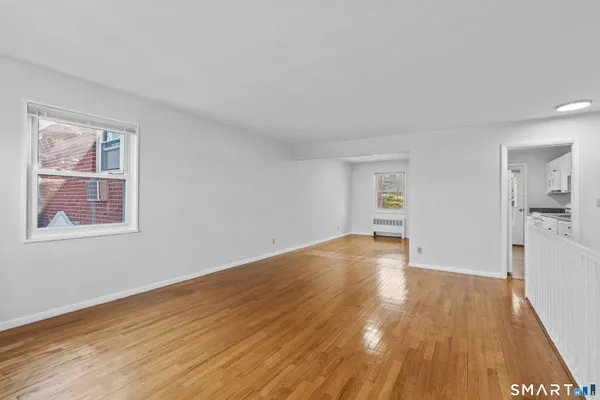 a view of a big room with wooden floor and windows