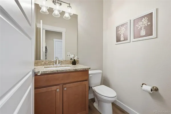 a bathroom with a granite countertop toilet sink and mirror