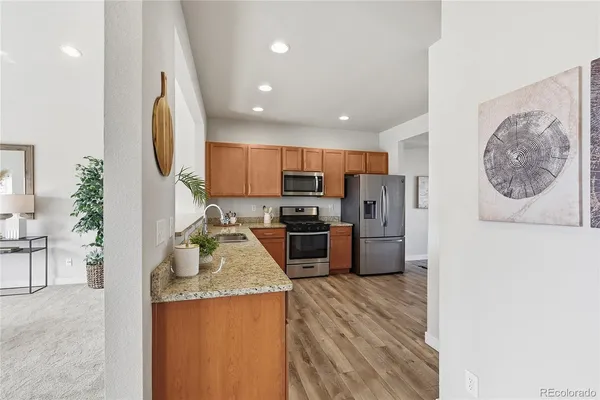 a kitchen with stainless steel appliances granite countertop a refrigerator sink and stove