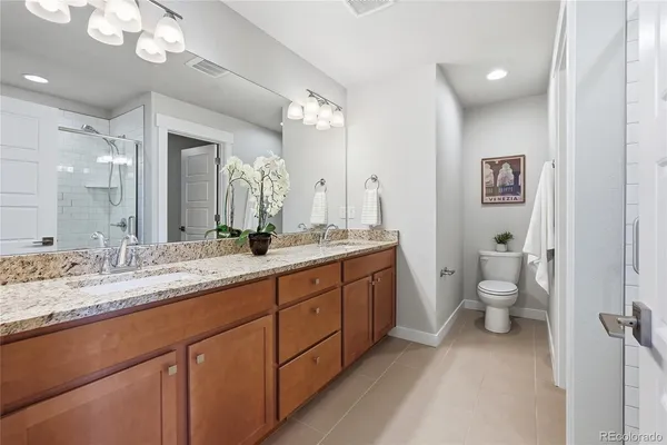 a bathroom with a granite countertop toilet sink and mirror