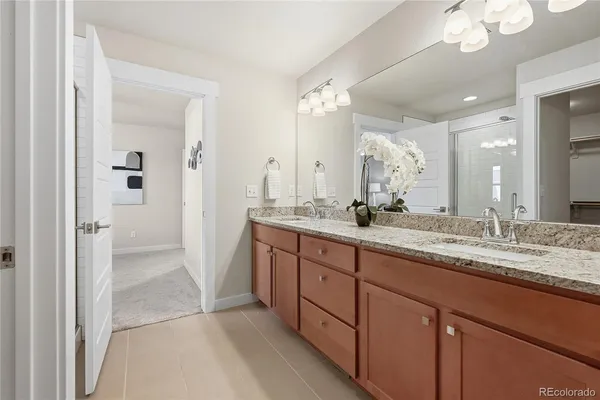 a bathroom with a granite countertop sink a mirror and a shower