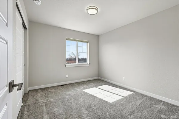 an empty room with windows and closet