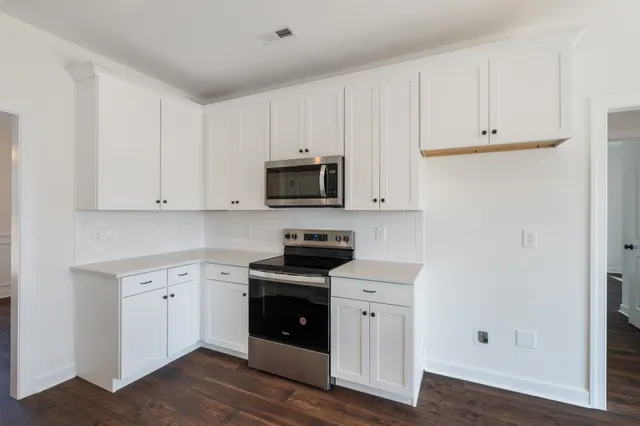 a kitchen with white cabinets and stainless steel appliances