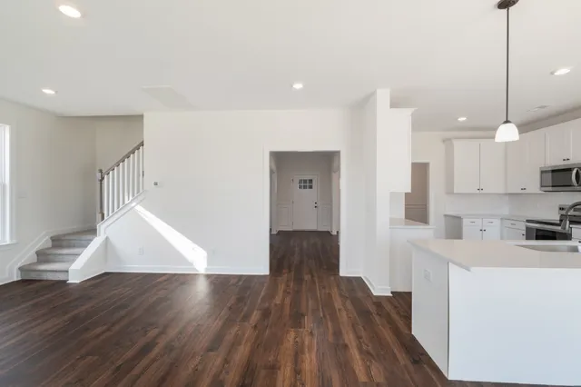 a view of a kitchen with wooden floor and electronic appliances