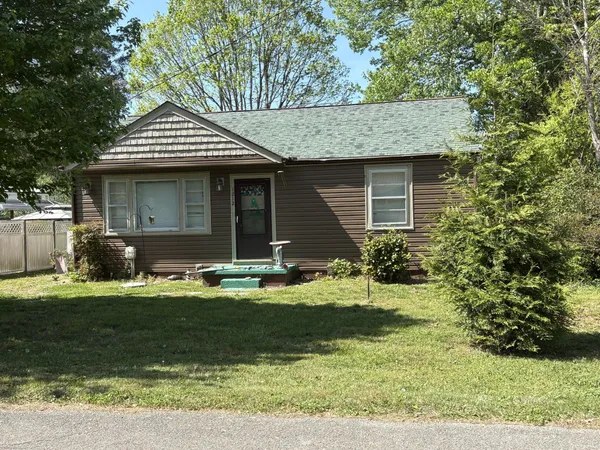 a view of a house with backyard and trees