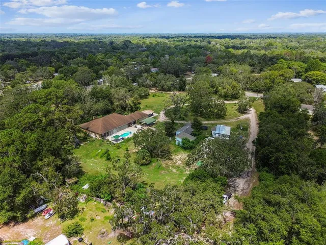a view of a swimming pool with lawn chairs under an umbrella