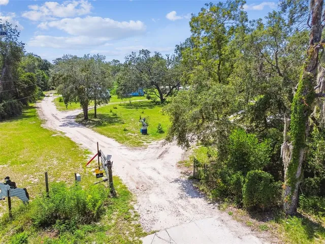 an aerial view of a house with outdoor space patio and trees all around