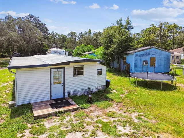 a view of a house with a big yard and large trees