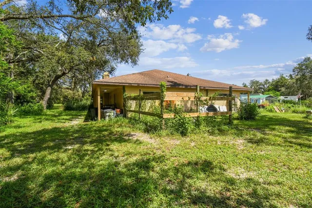 a view of a field with a lush green forest