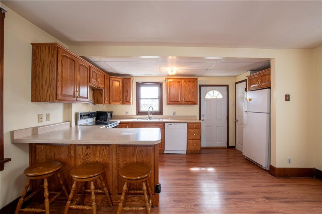 431 East Washington Street Rochester, PA 15074 - Photo 15 of 32 a kitchen with stainless steel appliances granite countertop a table chairs sink refrigerator and cabinets