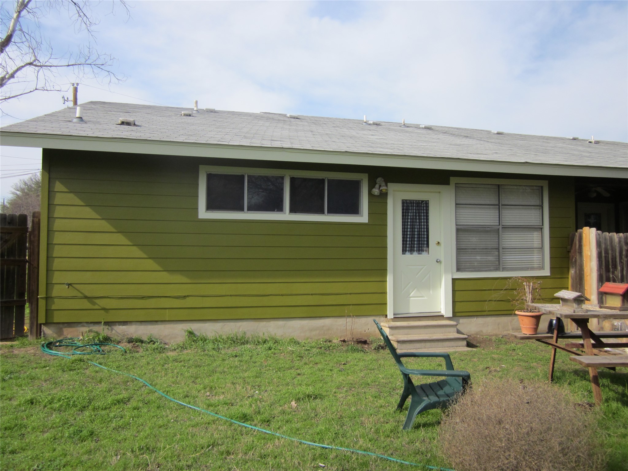 102 Verna Spur, Unit B Georgetown, TX 78628 - Photo 5 of 18 Back of house with entry steps and a shingled roof