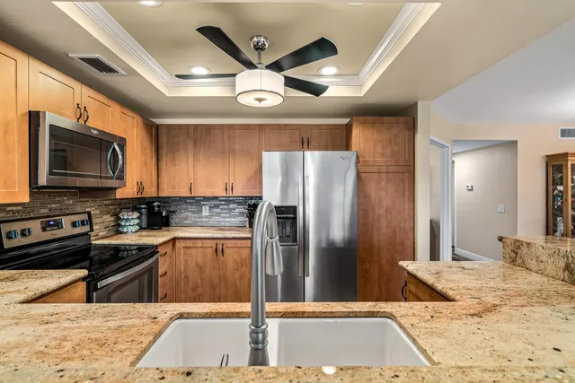 a kitchen with kitchen island granite countertop a stove and a sink