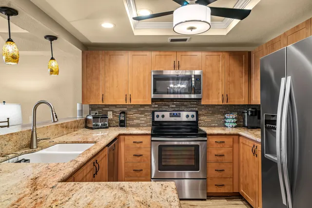 a kitchen with stainless steel appliances granite countertop a sink and stove top oven
