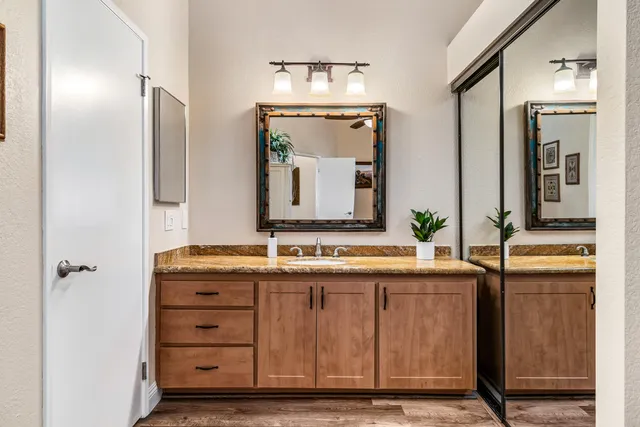 a bathroom with a granite countertop sink a toilet and a mirror