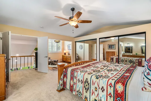 a spacious bedroom with a bed and a chandelier