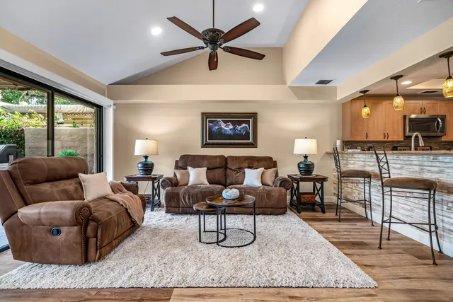 a living room with furniture a ceiling fan and a rug