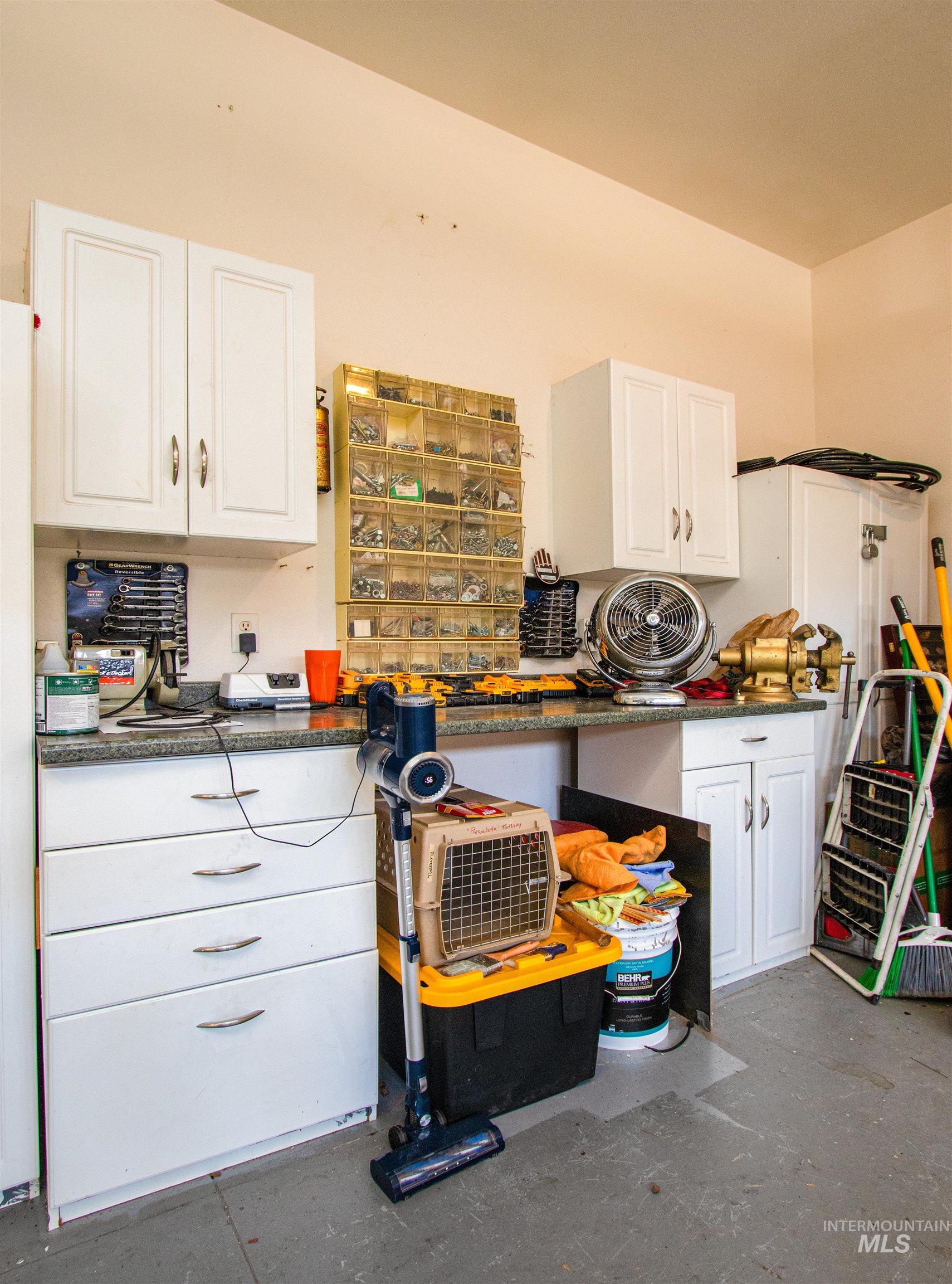 892 South Capitola Way Boise, ID 83712 - Photo 24 of 34 Garage workspace featuring white shaker-style cabinetry, a built-in countertop, and organized shelving