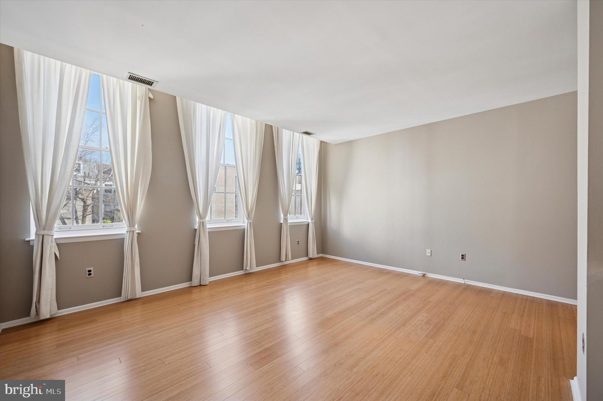 130 North Bread Street, Unit 310 Philadelphia, PA 19106 - Photo 13 of 16 a view of an empty room with a window and wooden floor