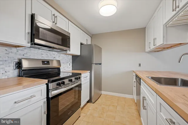 a kitchen with stainless steel appliances granite countertop a refrigerator stove and microwave