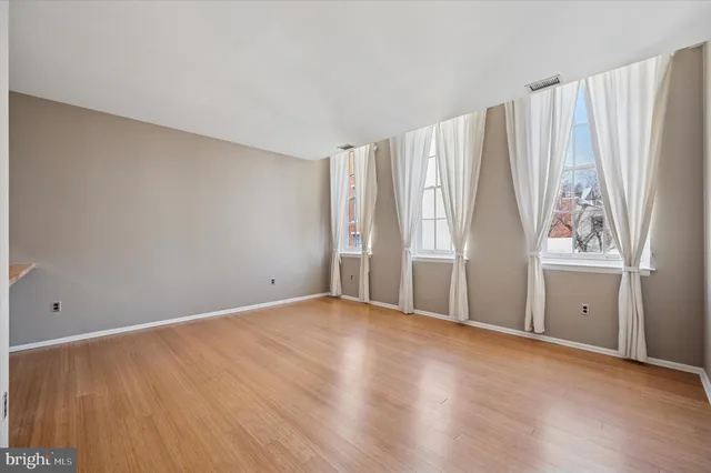a view of an empty room with wooden floor