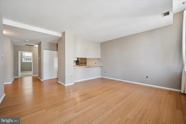 a view of empty room with wooden floor