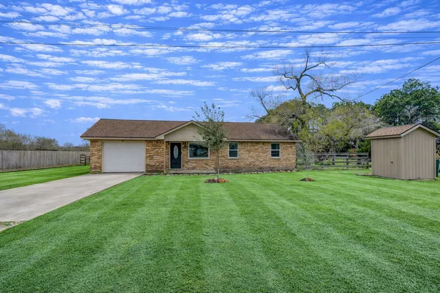 a aerial view of a house with a big yard plants and large tree