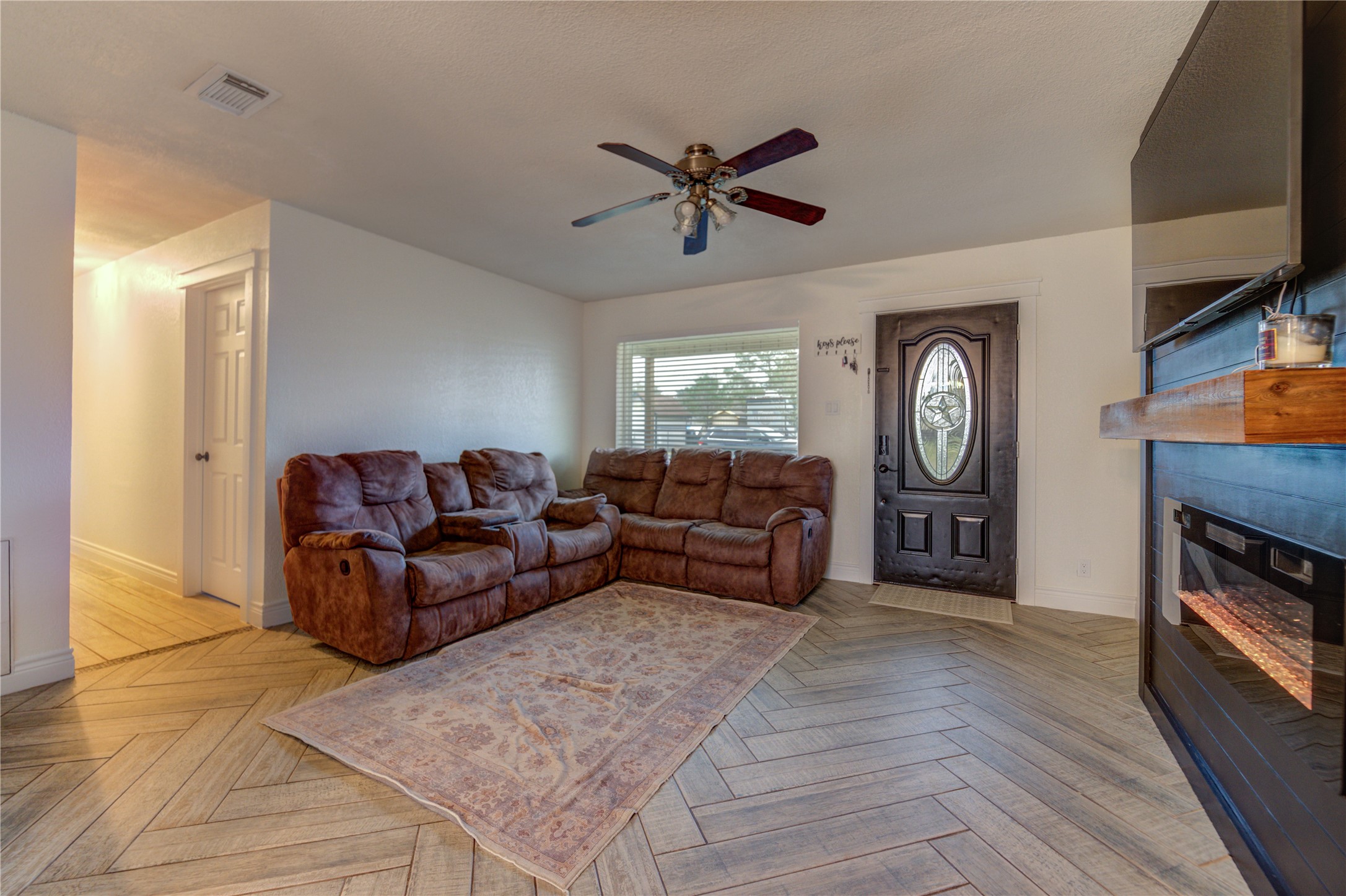 7706 Colston Place Santa Fe, TX 77510 - Photo 5 of 16 a living room with furniture a fireplace and a flat screen tv