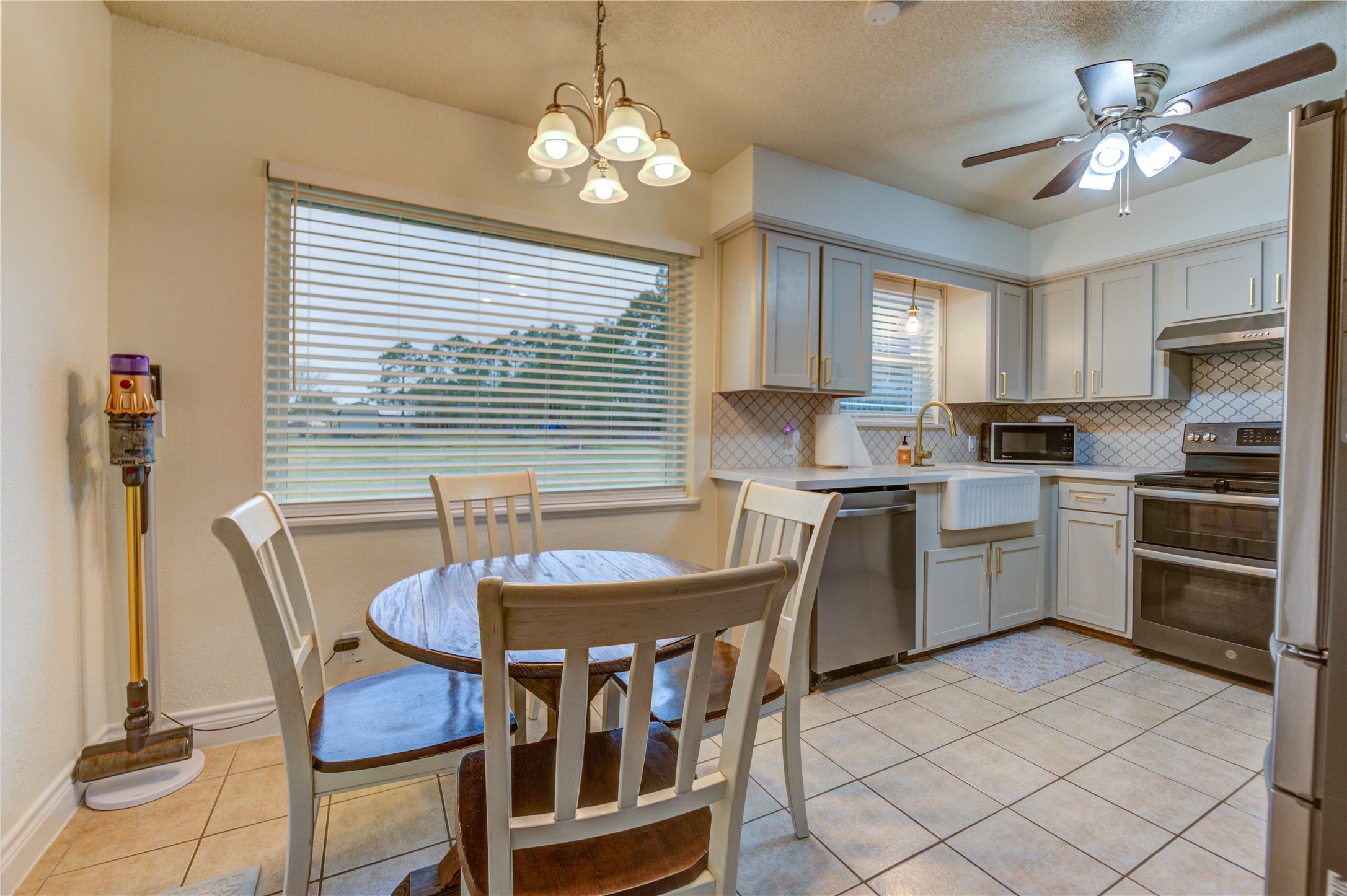 7706 Colston Place Santa Fe, TX 77510 - Photo 6 of 16 a kitchen with a table chairs a sink dishwasher and cabinets