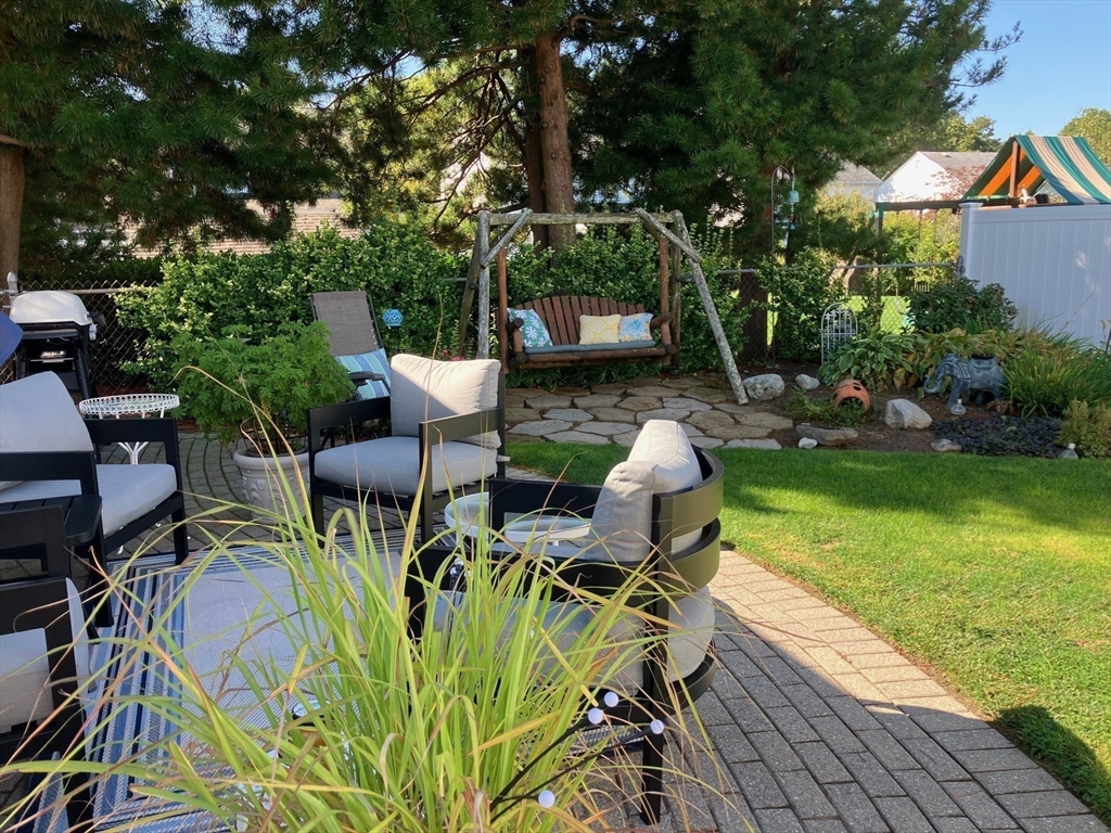 93 Crown Avenue Riverside, RI 02915 - Photo 28 of 33 a view of a patio with table and chairs potted plants and large tree
