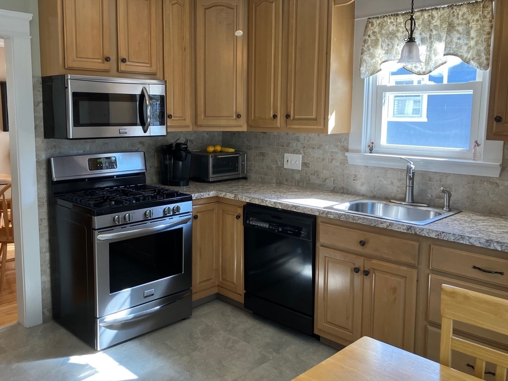 93 Crown Avenue Riverside, RI 02915 - Photo 9 of 33 a kitchen with granite countertop a stove top oven microwave and cabinets