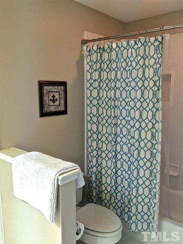 5805 Sand Pebble Place Raleigh, NC 27613 - Photo 13 of 17 a bathroom with a toilet and a shower curtain