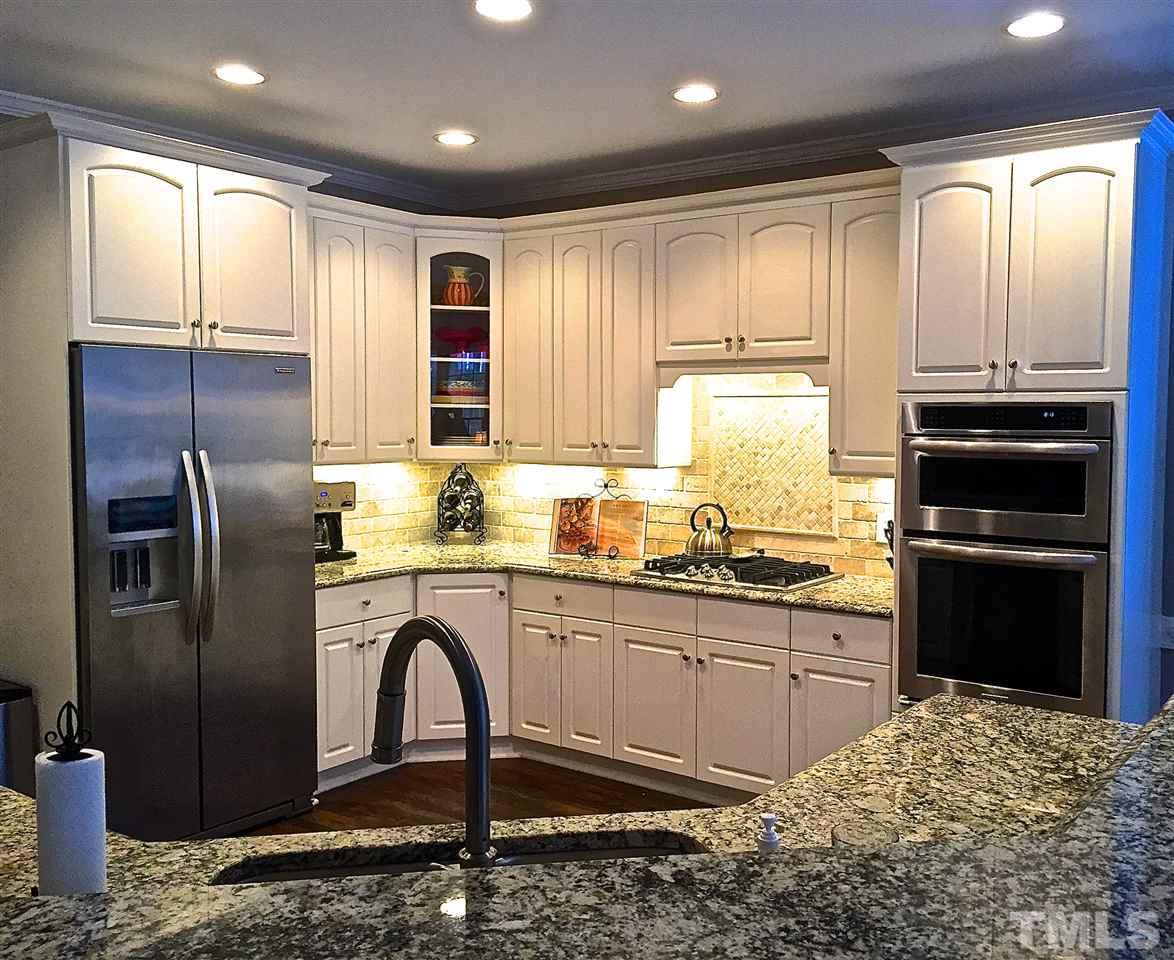 5805 Sand Pebble Place Raleigh, NC 27613 - Photo 3 of 17 a kitchen with stainless steel appliances granite countertop a refrigerator a stove a sink and a microwave