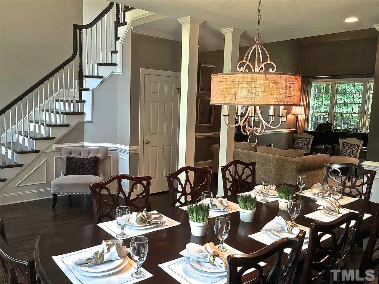 5805 Sand Pebble Place Raleigh, NC 27613 - Photo 8 of 17 a dining room with furniture a rug and a chandelier