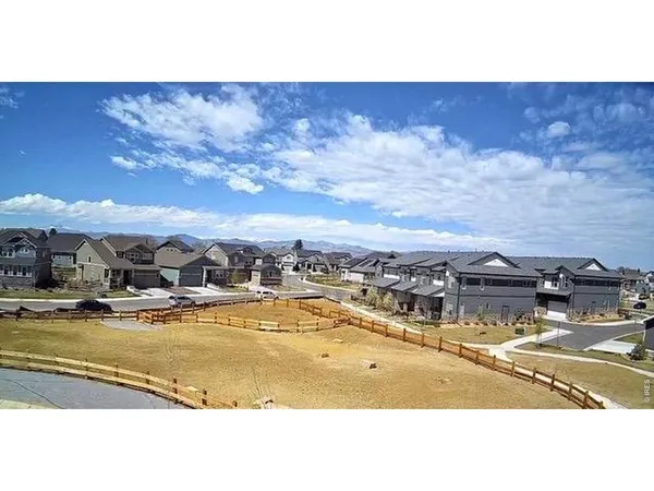 a view of a pathway both side of grassy field with shrub