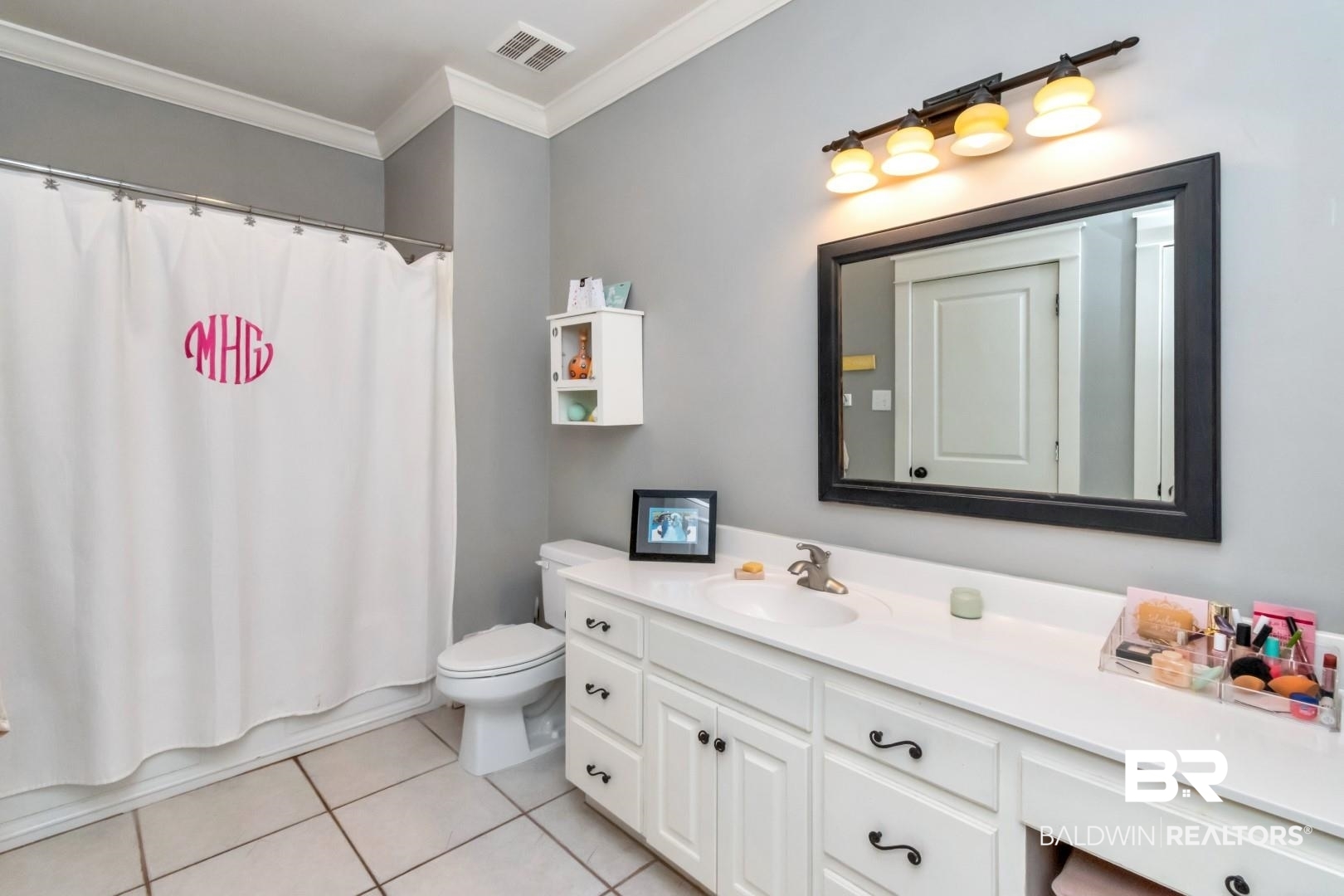 8868 Dawes Lake Road South Mobile, AL 36619 - Photo 25 of 35 Full bathroom featuring shower / bath combination with curtain, toilet, vanity, crown molding, and tile patterned flooring