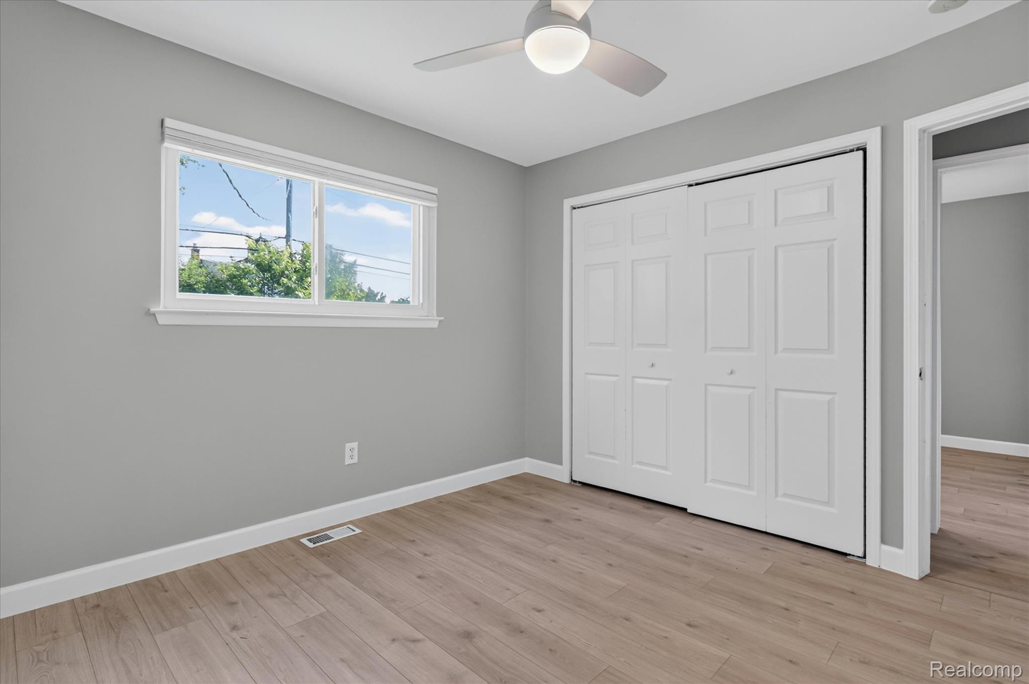 934 Harvard Road Berkley, MI 48072 - Photo 22 of 34 Room featuring wood-finish flooring, a double-pane window with white trim, and a ceiling fan with integrated lighting