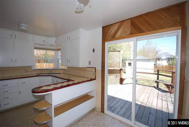 1024 Bell Street Reno, NV 89503 - Photo 6 of 13 a kitchen with granite countertop a stove and white cabinets with wooden floor