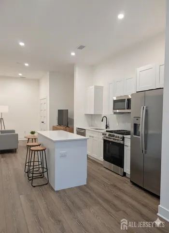 a kitchen with stainless steel appliances a refrigerator and a stove top oven