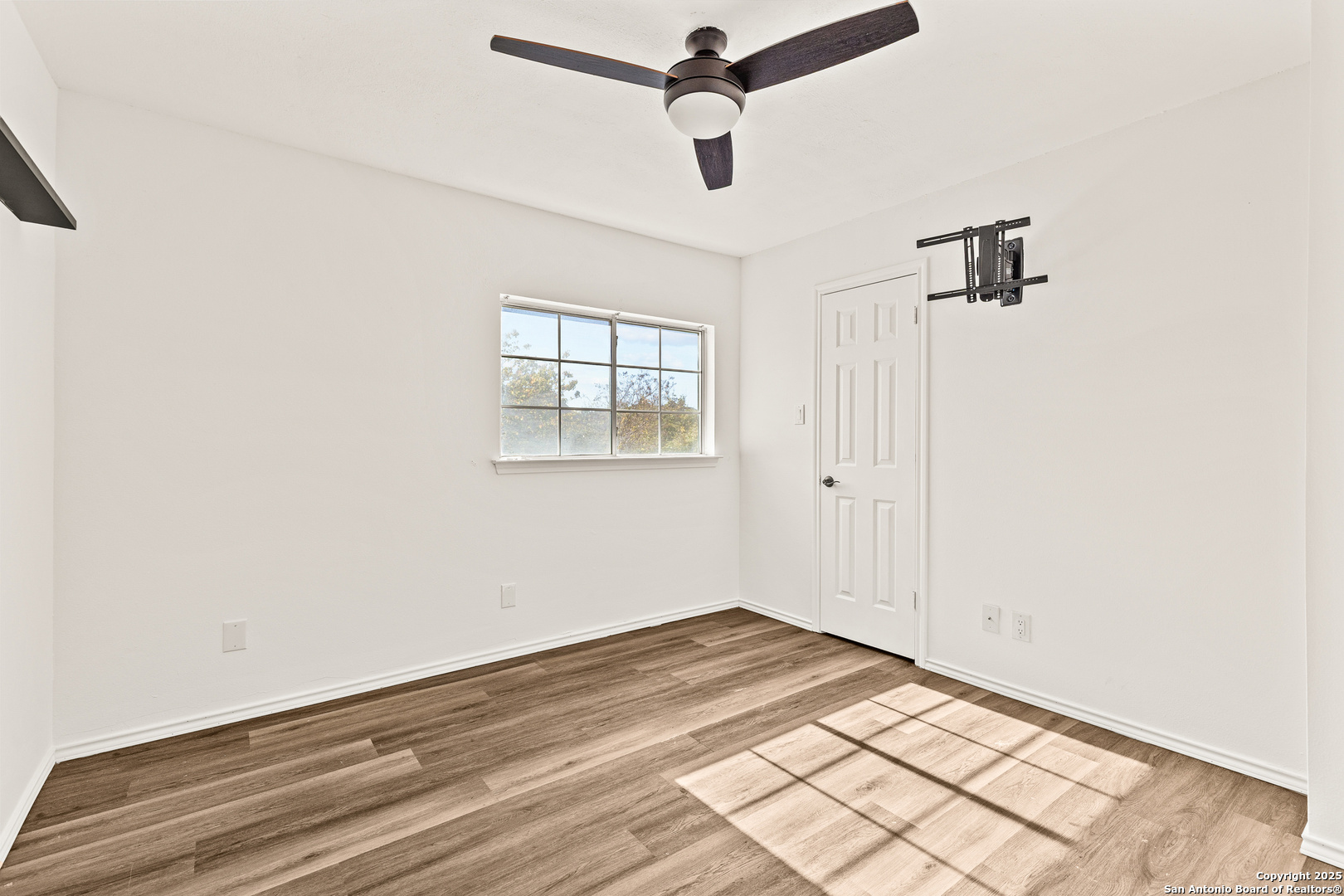 1687 Fir Circle Schertz, TX 78154 - Photo 19 of 25 an empty room with wooden floor ceiling fan and windows