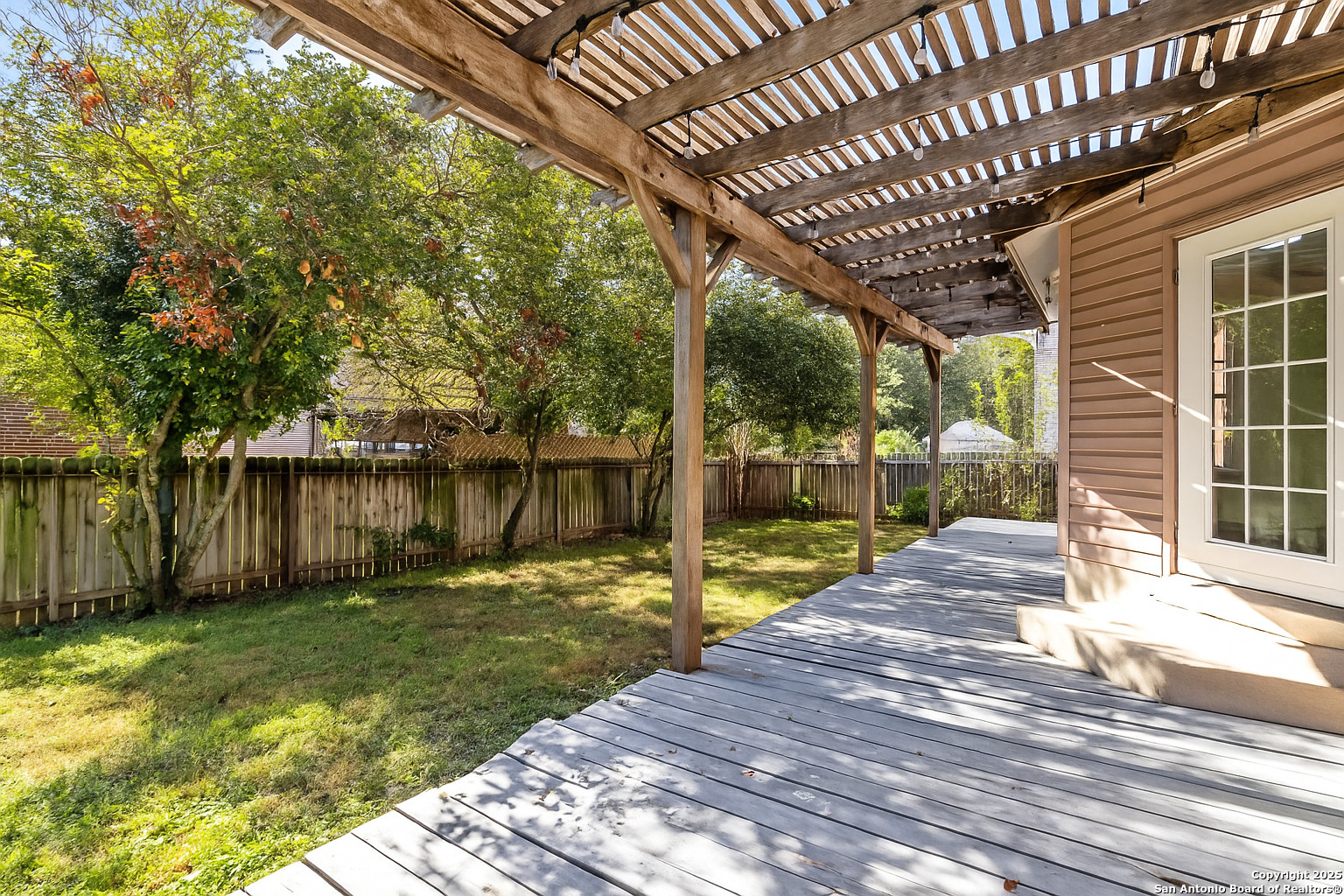 1687 Fir Circle Schertz, TX 78154 - Photo 23 of 25 a view of a backyard with table and chairs and wooden fence