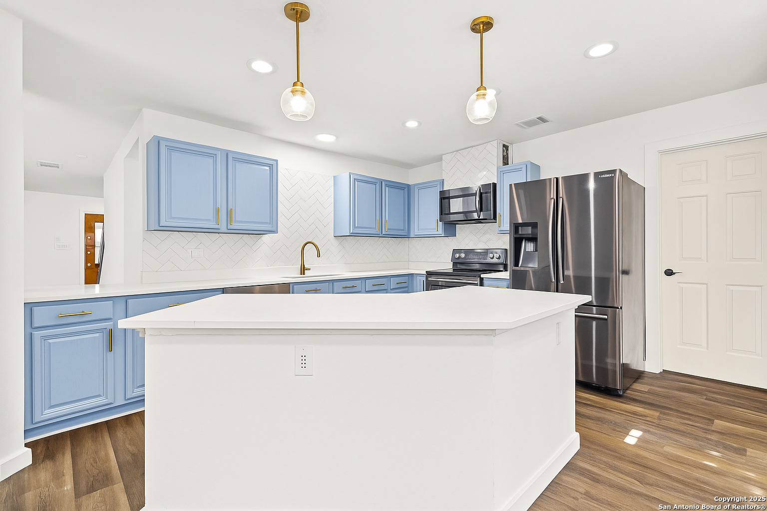 1687 Fir Circle Schertz, TX 78154 - Photo 9 of 25 a kitchen with kitchen island a stove a sink dishwasher a refrigerator and cabinets with wooden floor
