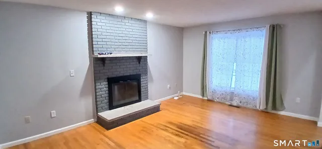 a view of an empty room with a fireplace and a window