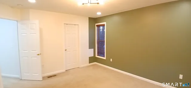 a view of a livingroom with an empty space and a window