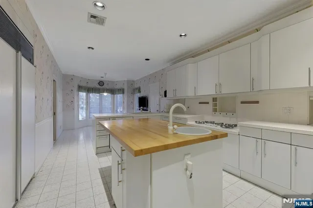 a kitchen with kitchen island sink stove and cabinets